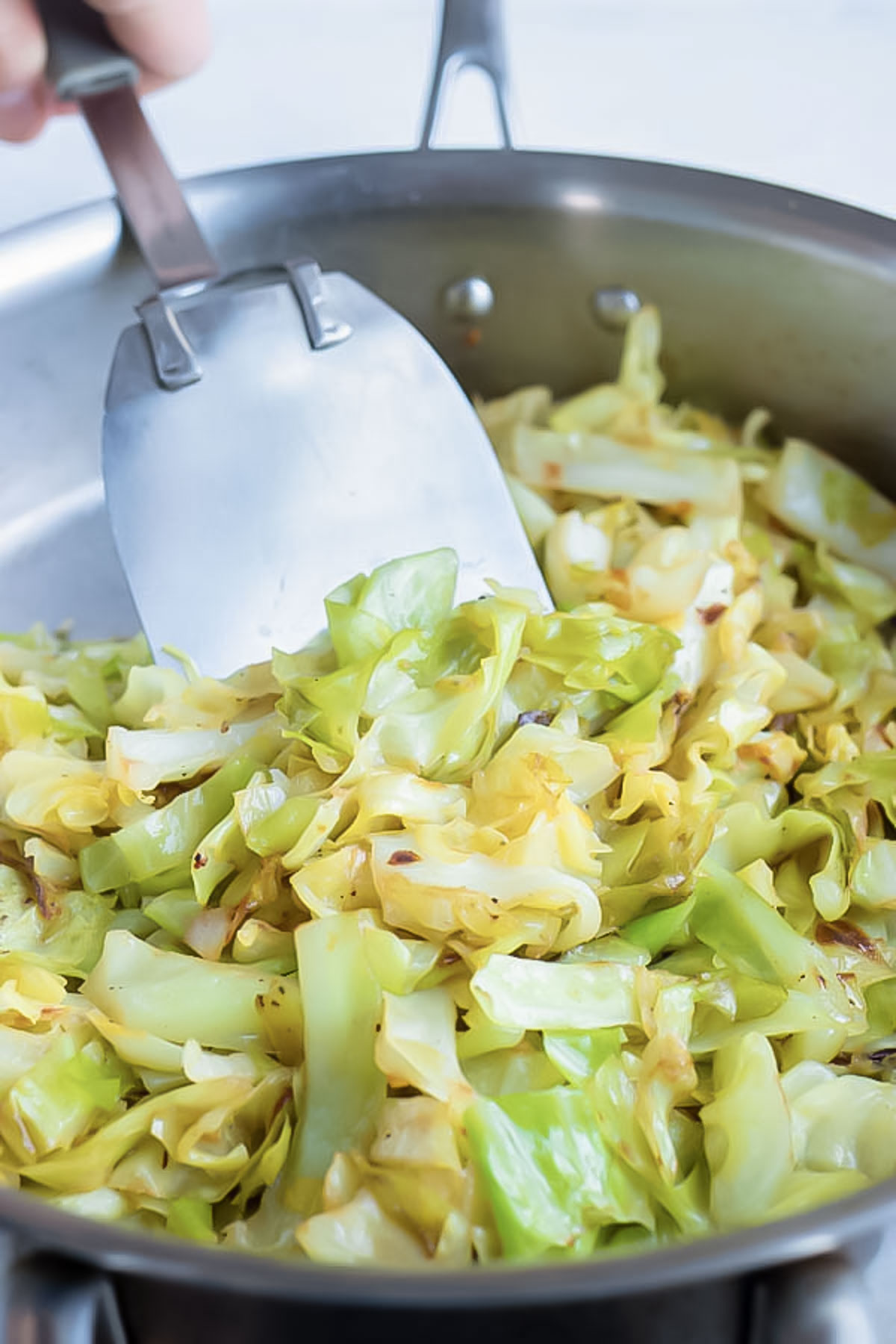 Cabbage is sautéed on the stove for a healthy side dish.