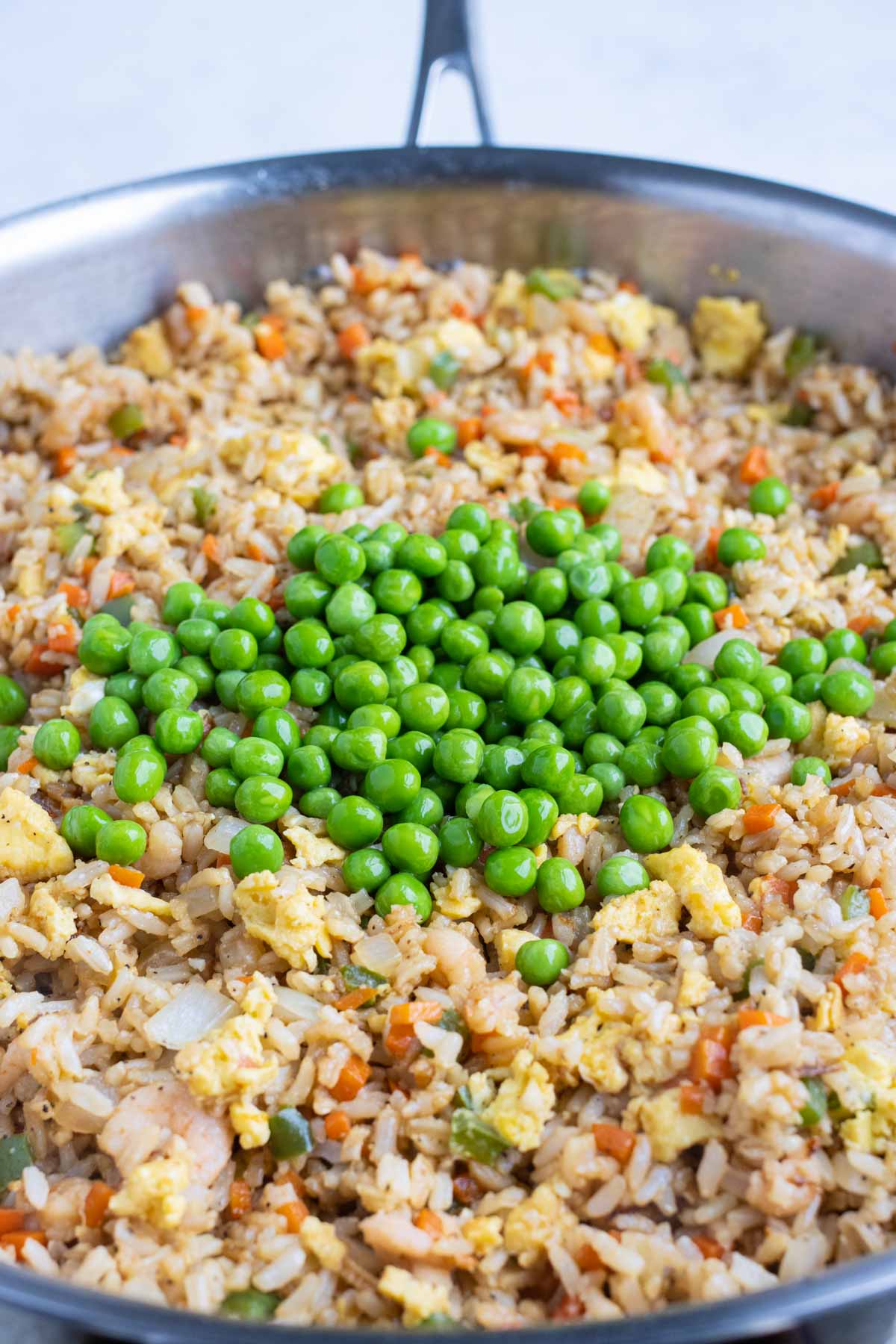 Peas are added lastly to the fried rice.