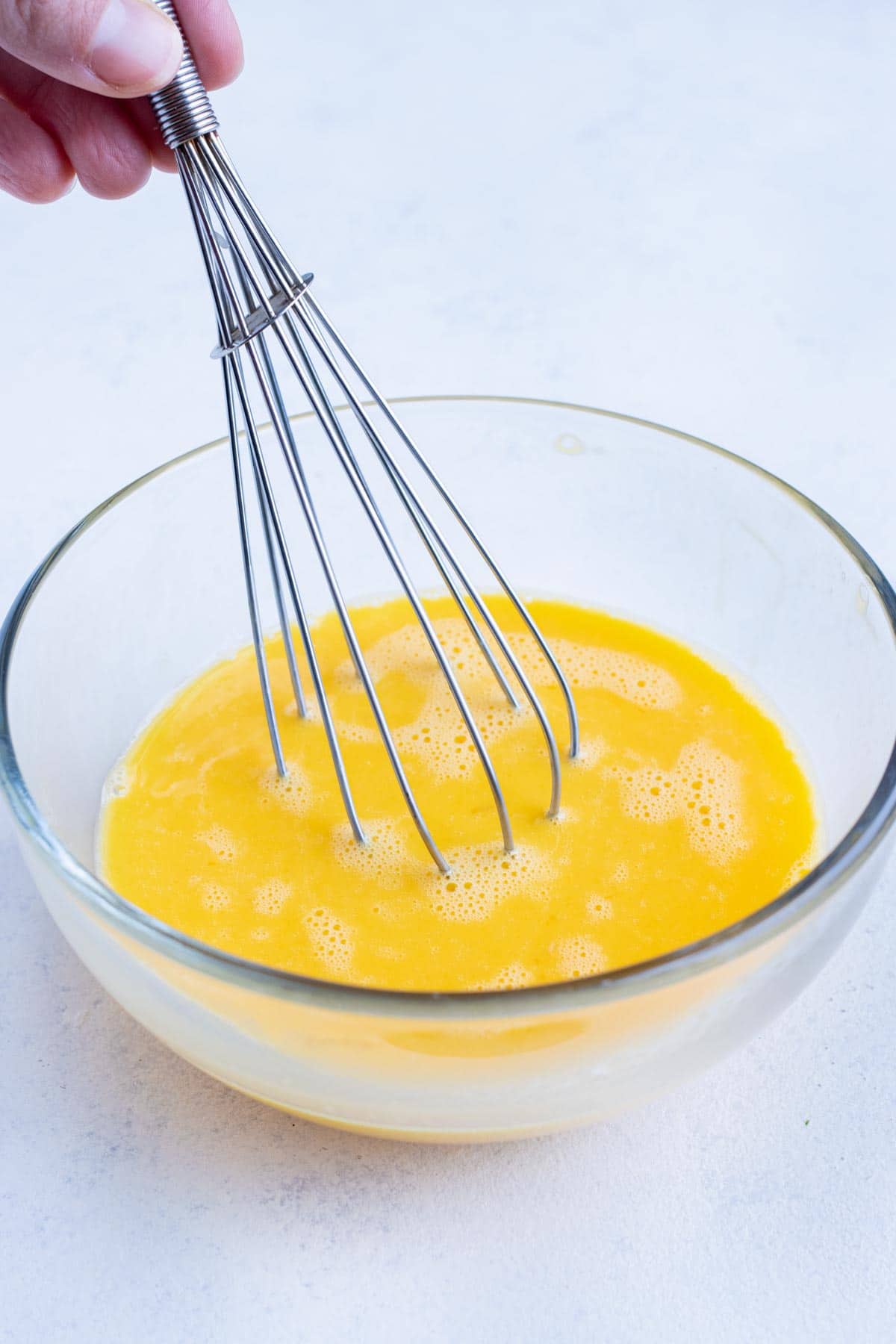 Eggs are whisked in a bowl for this recipe.