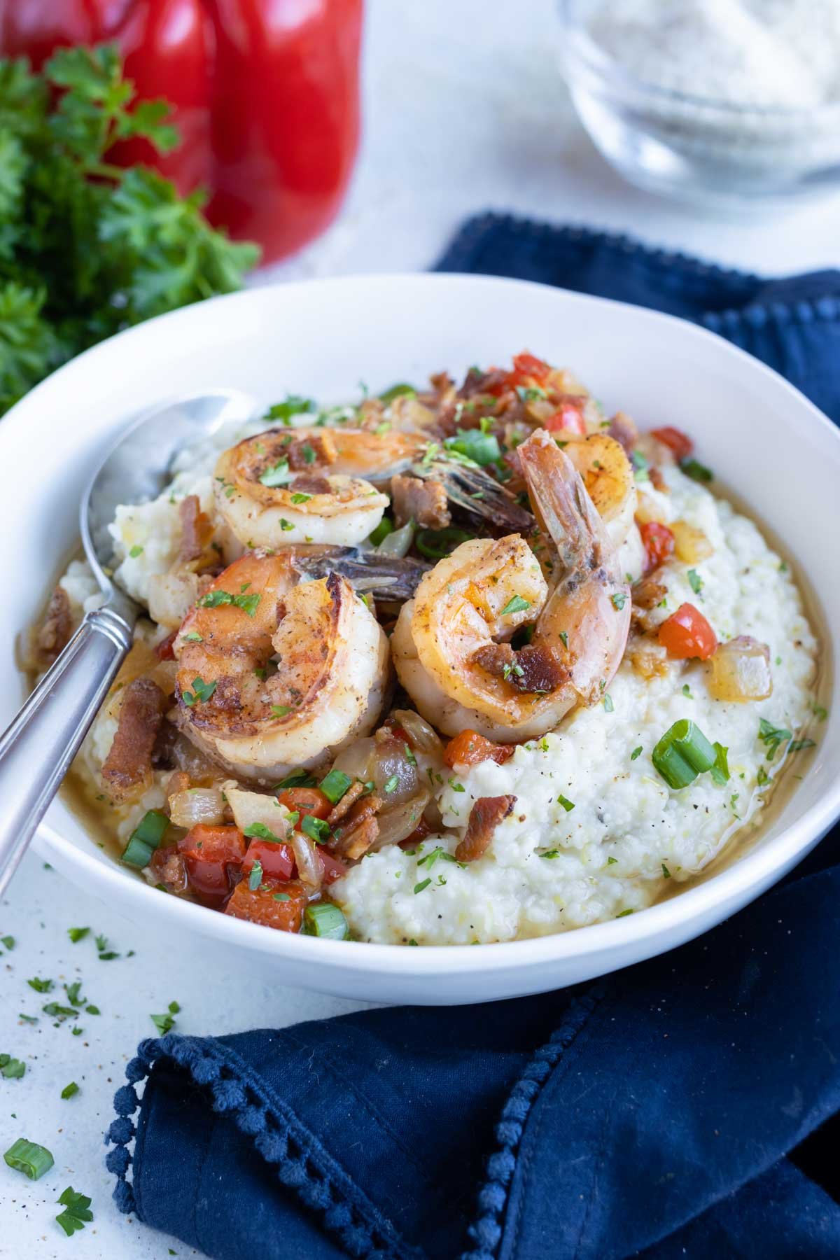 A spoon is used to eat traditional southern shrimp and grits.