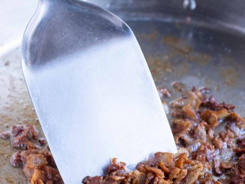 Bacon is cooked in a pan for an easy shrimp and grits.