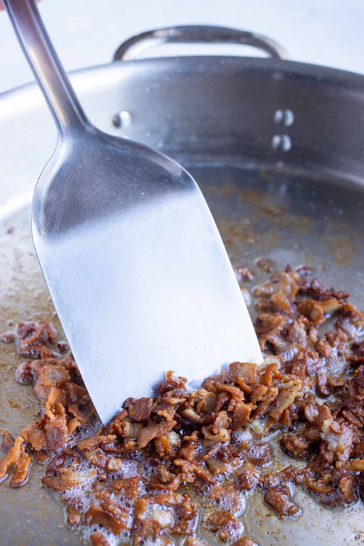 Bacon is cooked in a pan.