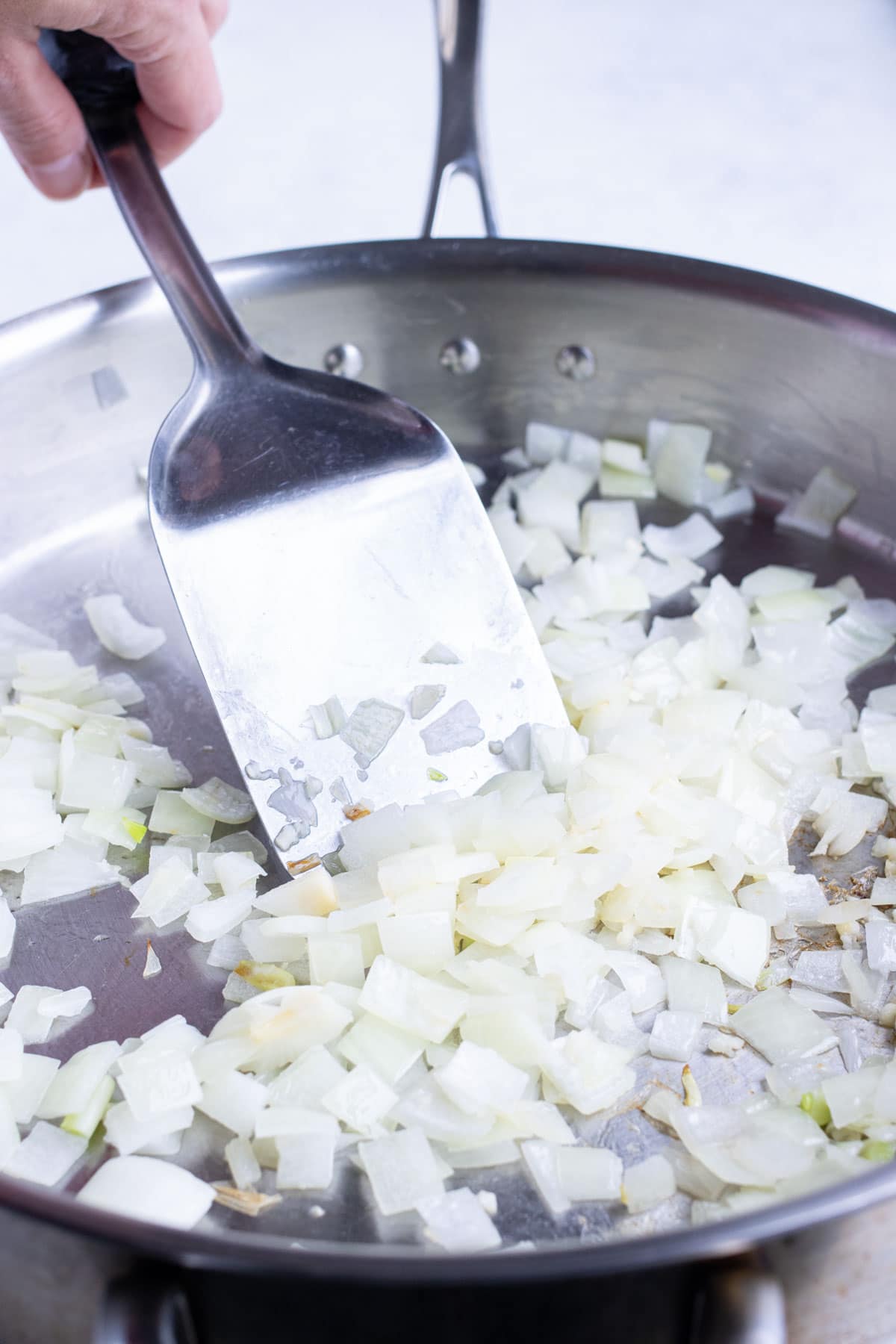 Diced onions are sautéed in the skillet.