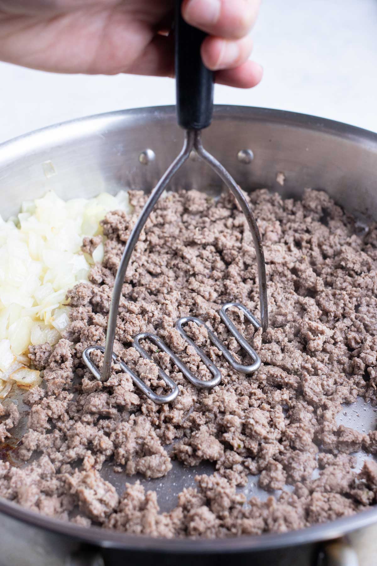 Ground beef is cooked in crumbles in the skillet.