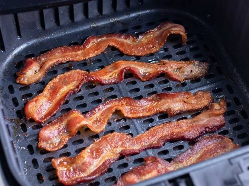 Bacon cooks in the air fryer until crispy.