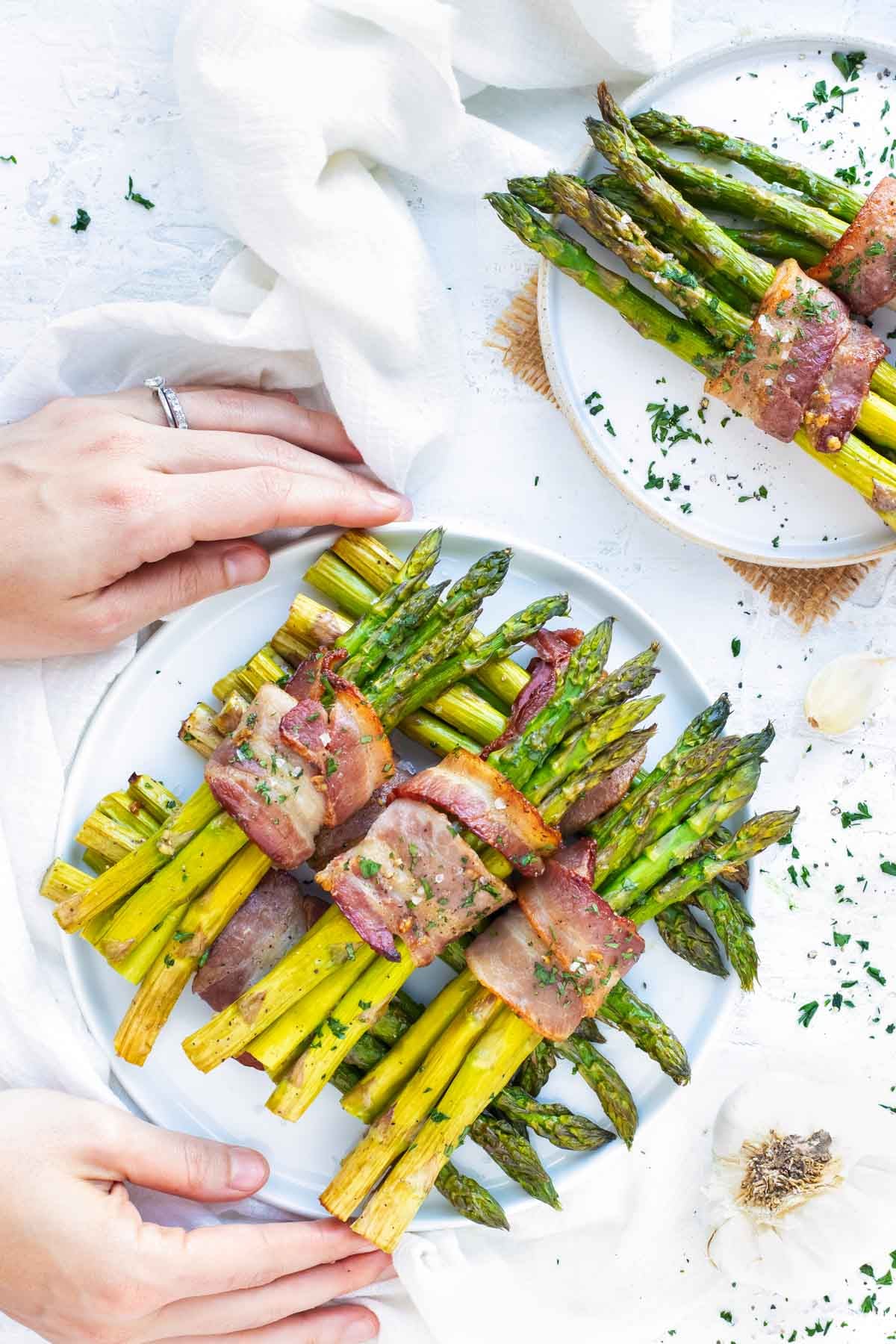 A plate full of bacon wrapped asparagus bundles.