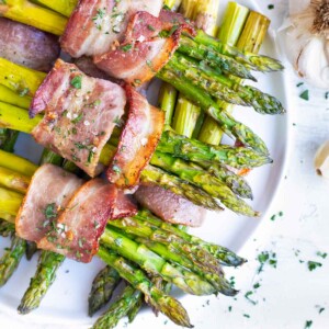 Bacon Wrapped Asparagus is a low-carb, keto, and healthy side dish recipe that is great for weeknight dinners or as a Thanksgiving Day vegetable dish!  Learn the ingredients, tools, and techniques that will teach you how to make bacon wrapped asparagus that turns out perfectly every single time!