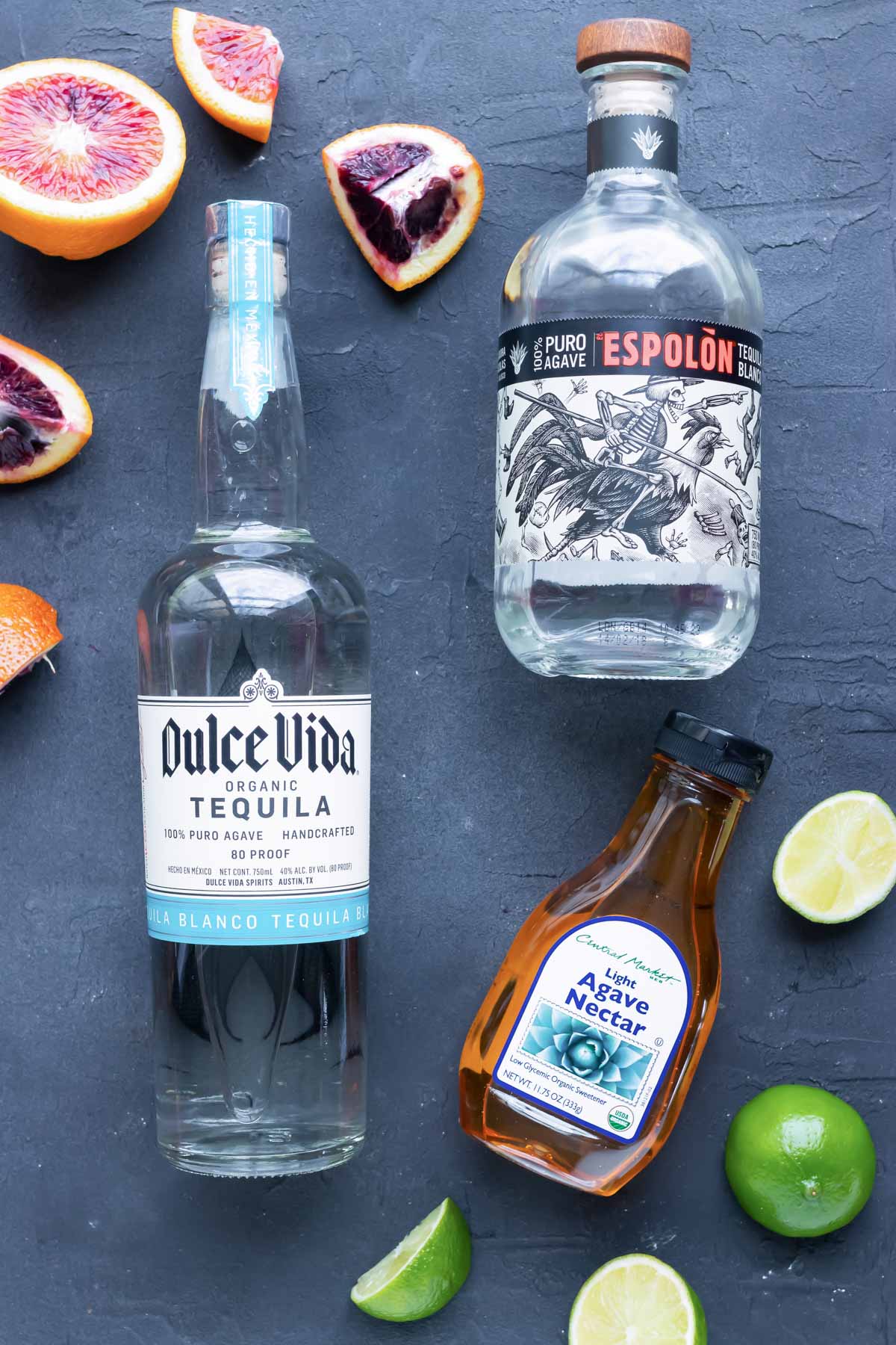 The best tequila for margaritas and other margarita ingredients on a black background.