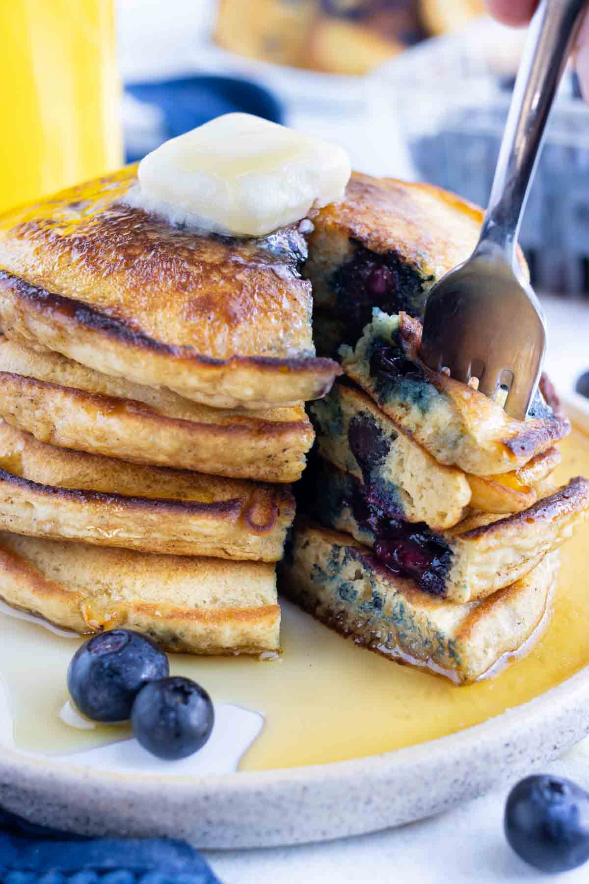 A fork is used to enjoy blueberry pancakes.