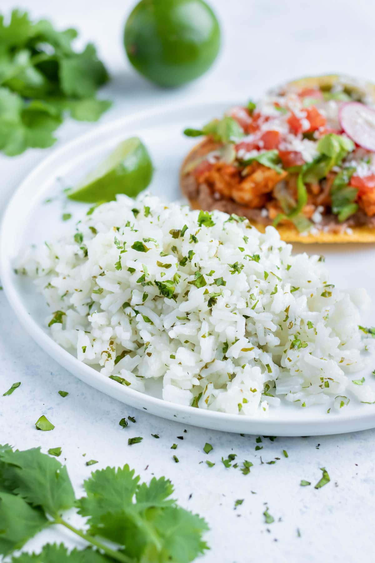 A side of cilantro lime rice is served with tacos on a plate.