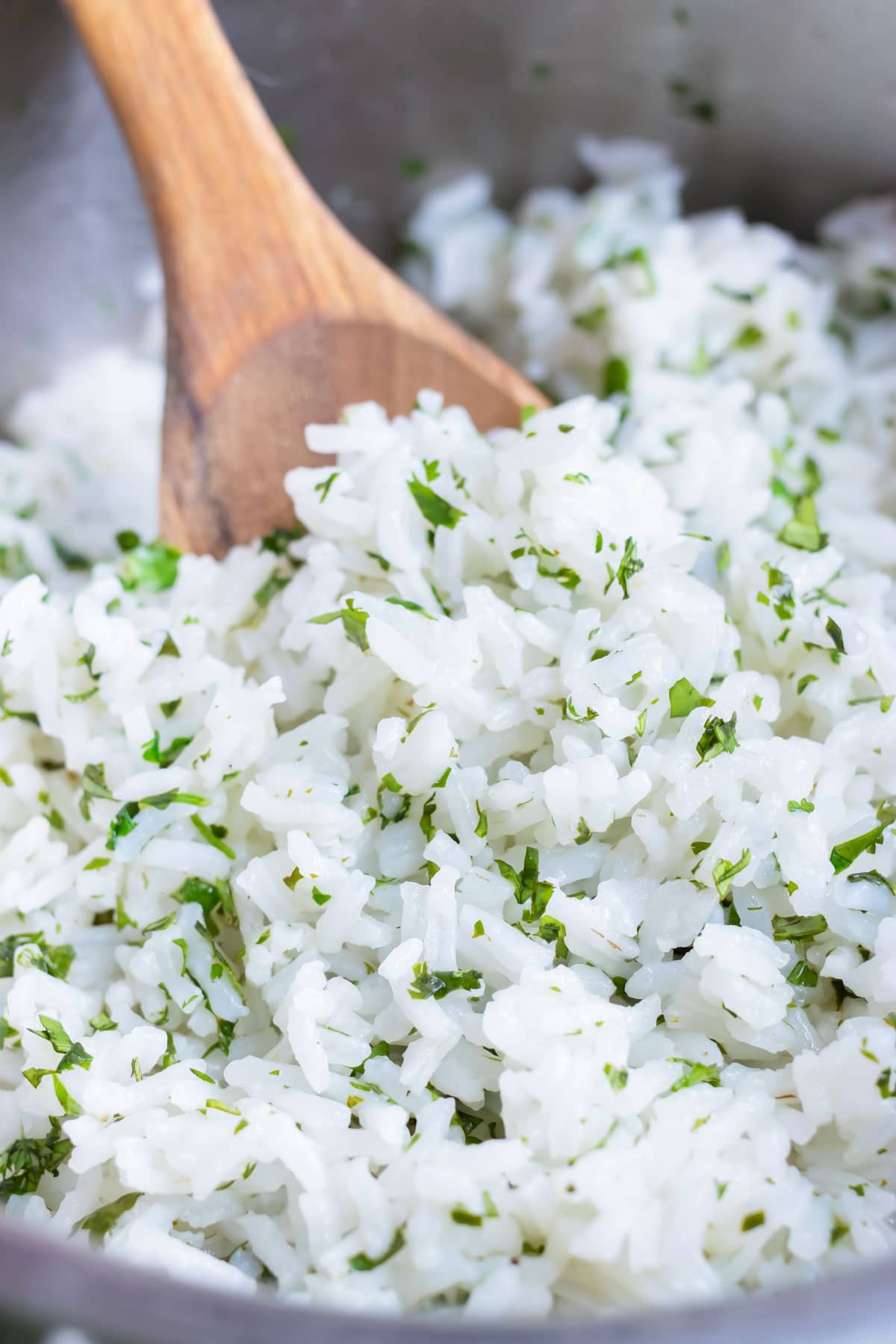 Flavorful cilantro lime rice is served with a spoon for a side dish.