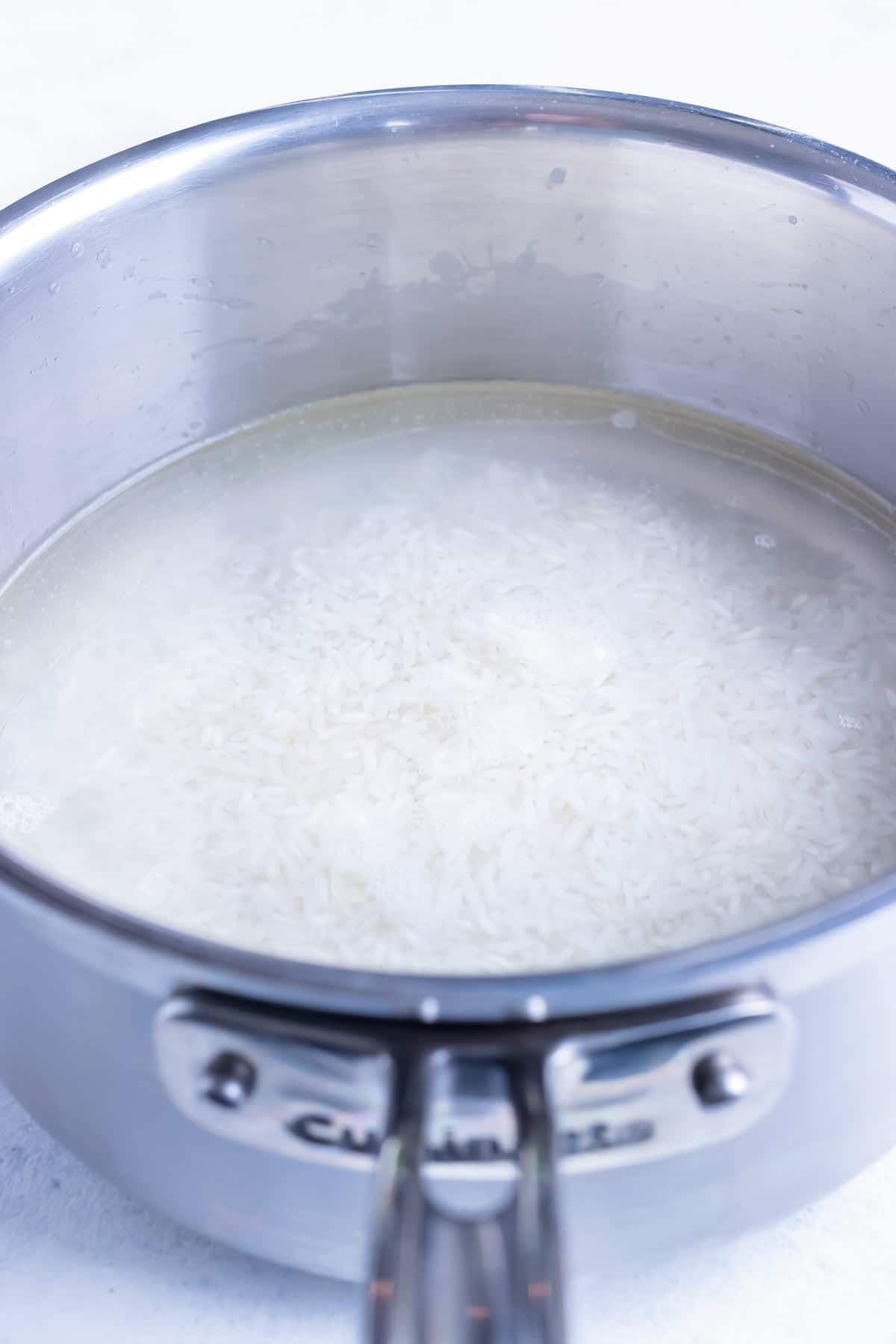 Rice is covered with water and boiled on the stove.