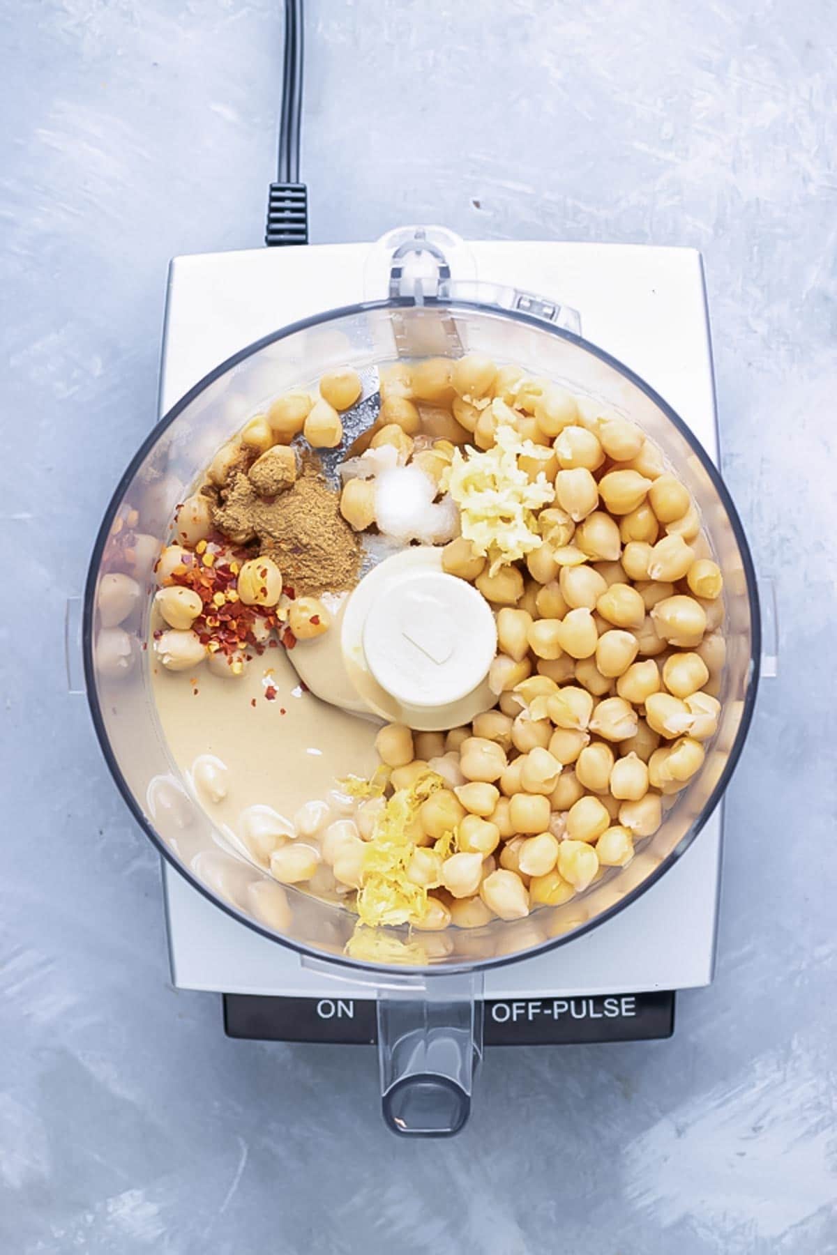 The ingredients for hummus are combined in a food processor.