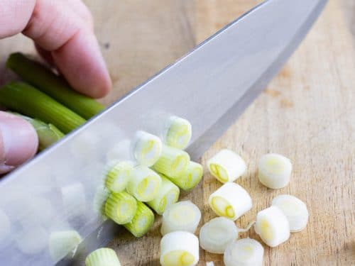 The white part of the green onions is sliced.