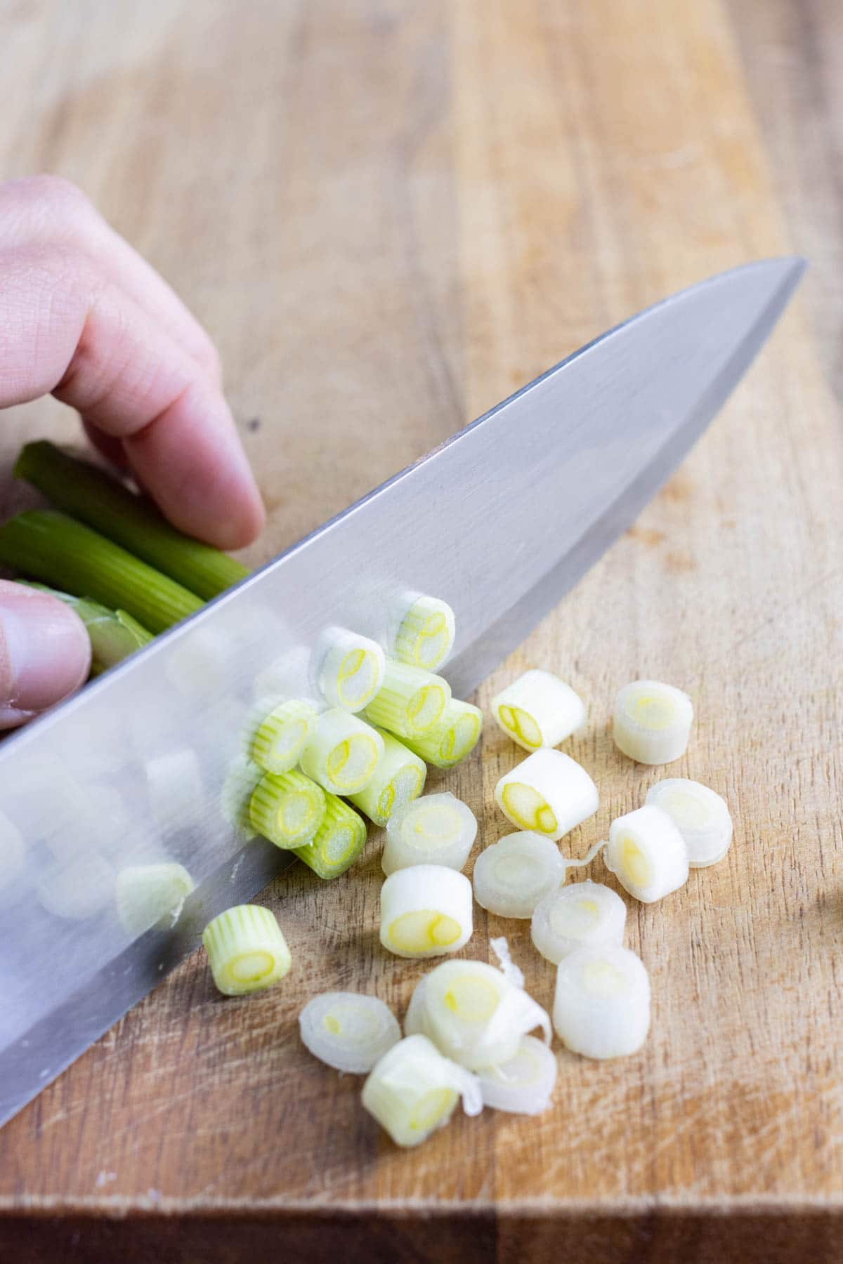 The white part of the green onions is sliced.