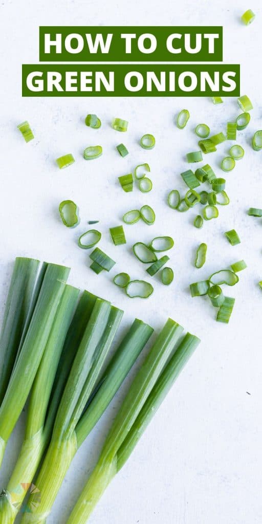 Chopped green onions are set on the counter near near whole green onions.