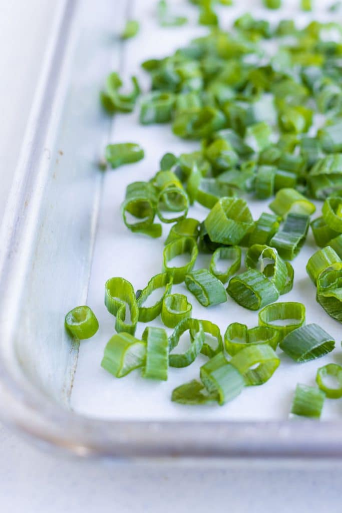 Green onions are chopped and laid on a baking sheet to freeze.