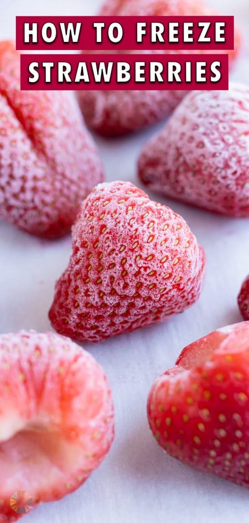 Frozen strawberries are shown on a baking sheet.