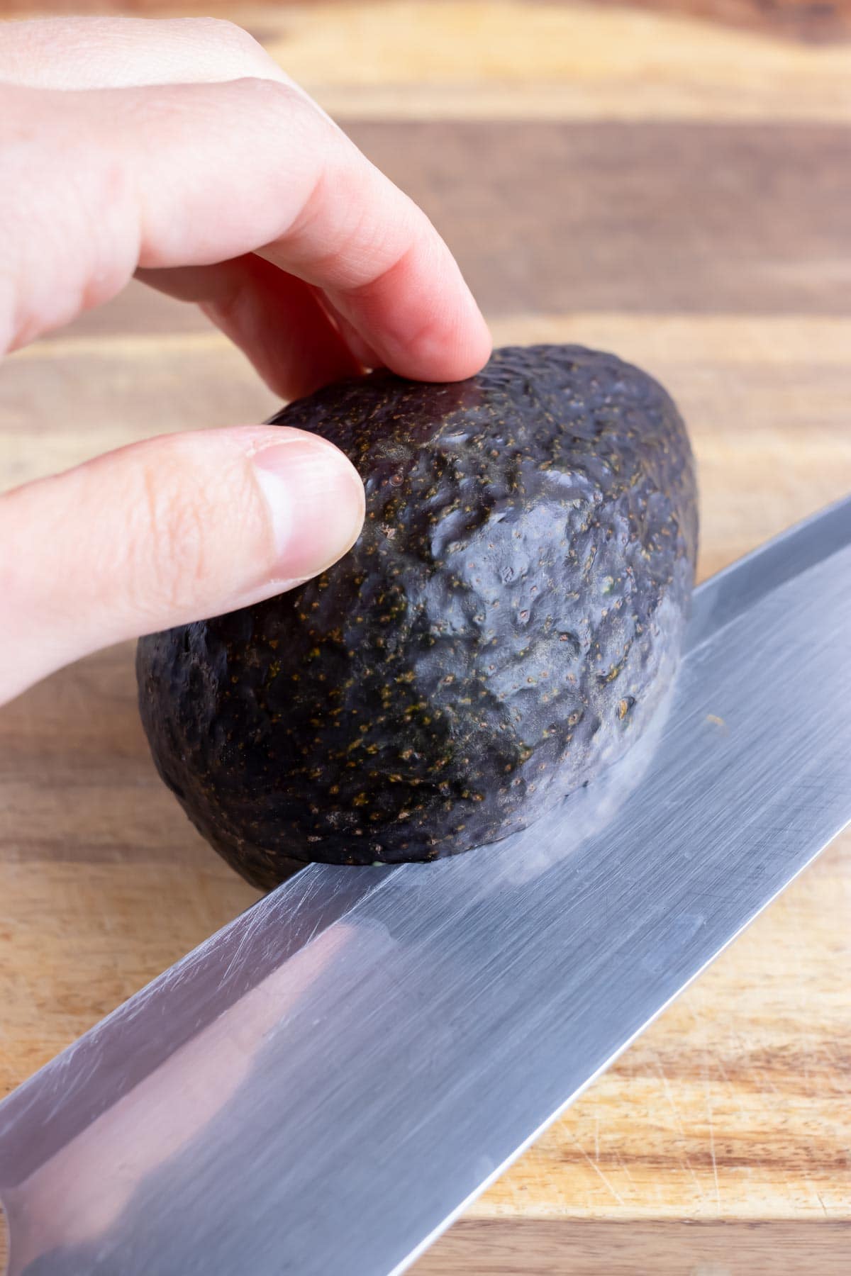 Cut an avocado in half with a sharp knife