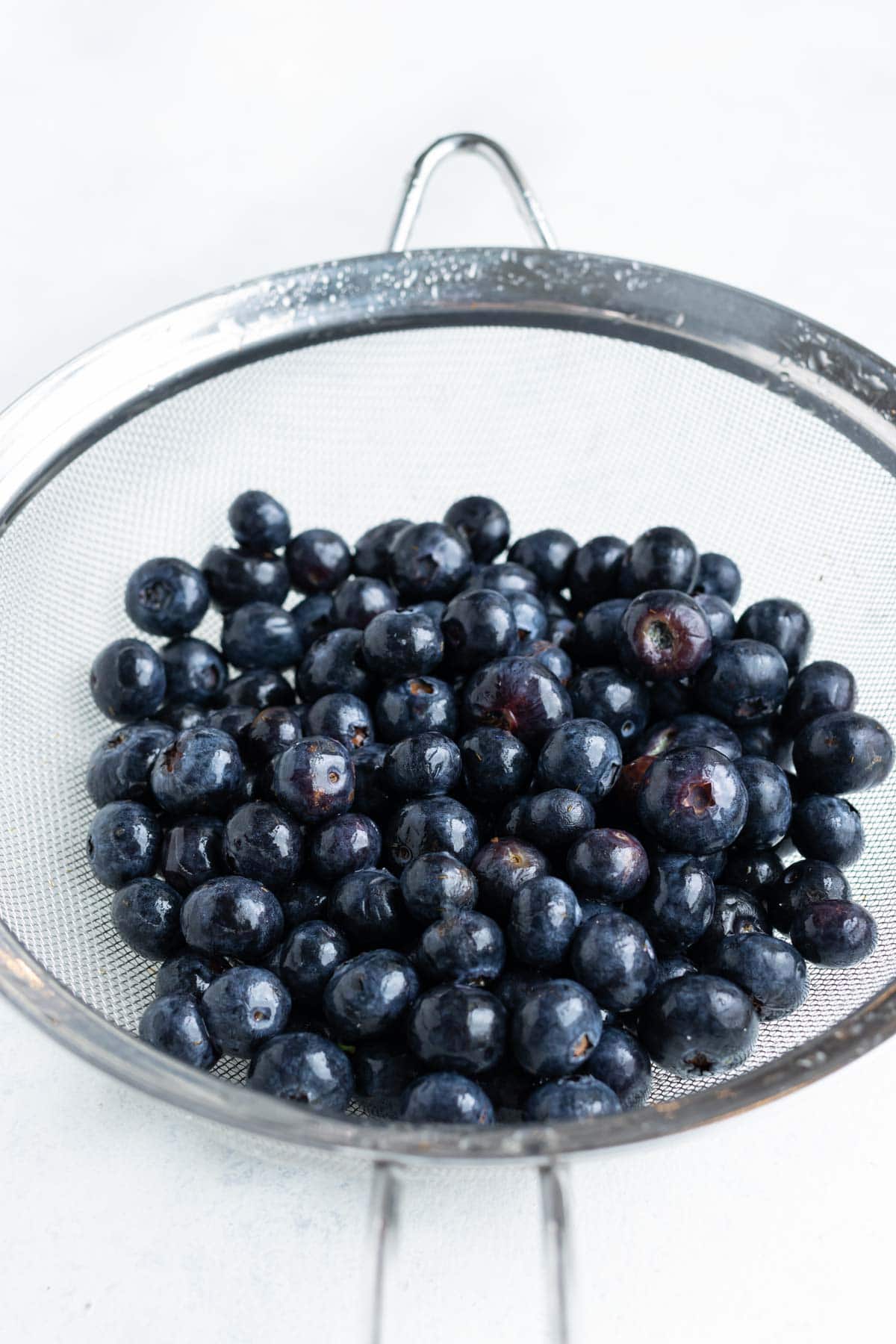 Fresh blueberries are prepared and washed before laying flat.