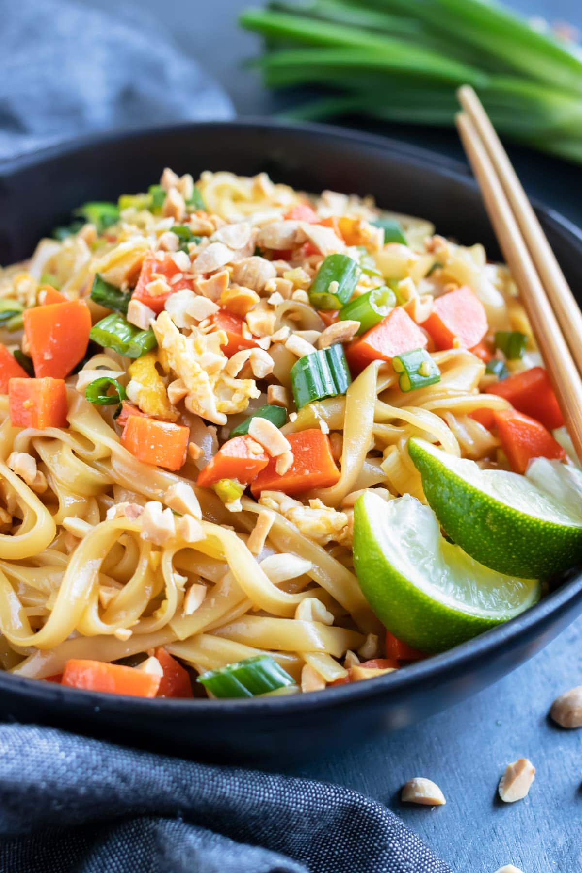 A healthy, gluten-free rice noodle stir-fry dish with chopsticks.