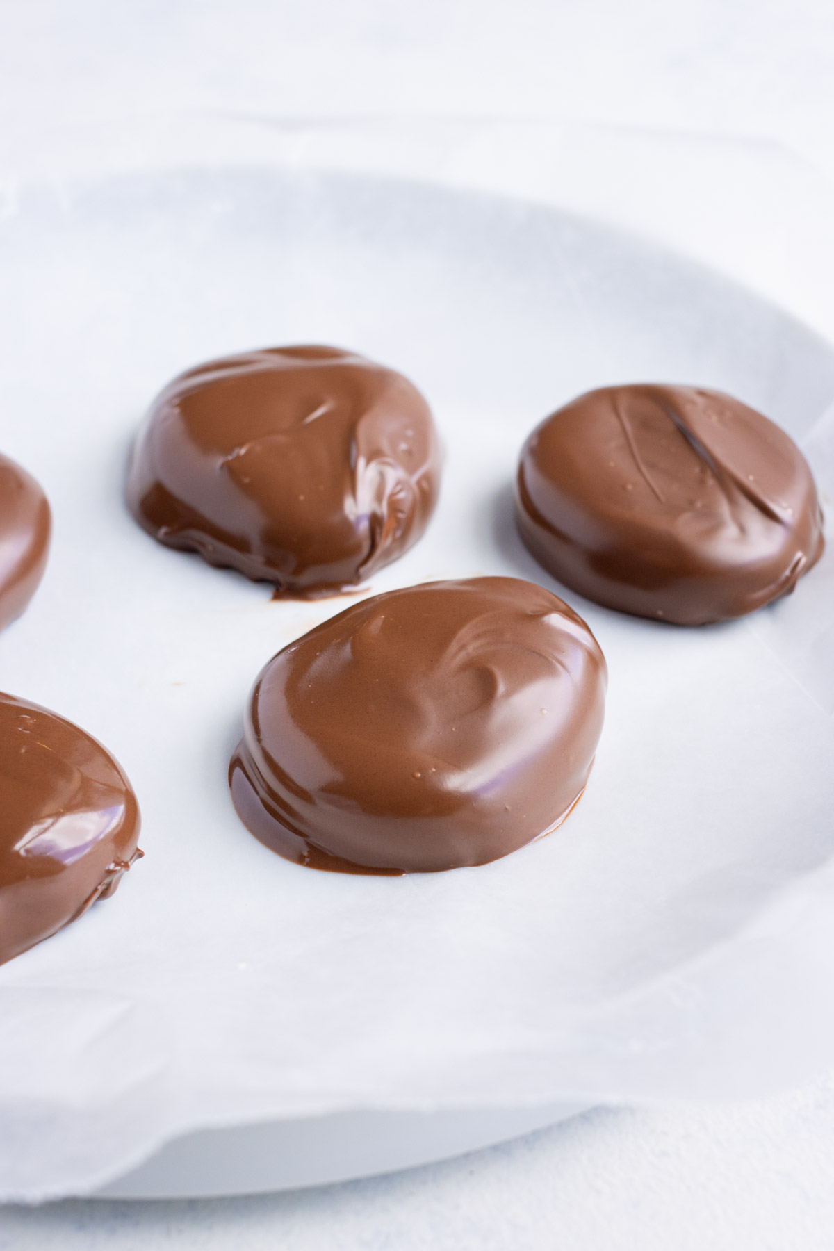 Chocolate peanut butter eggs are laid on wax paper to set.
