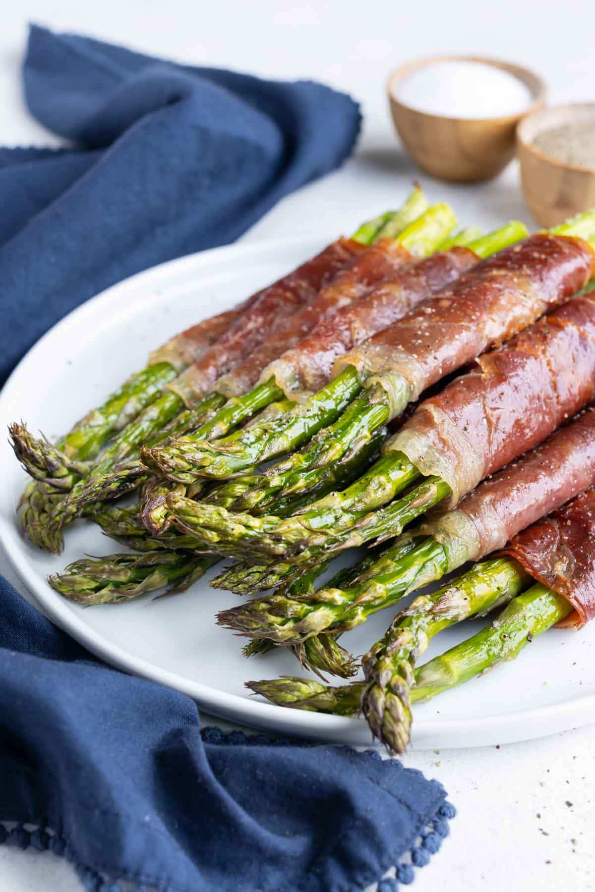 A white plate is used to serve this asparagus side dish.