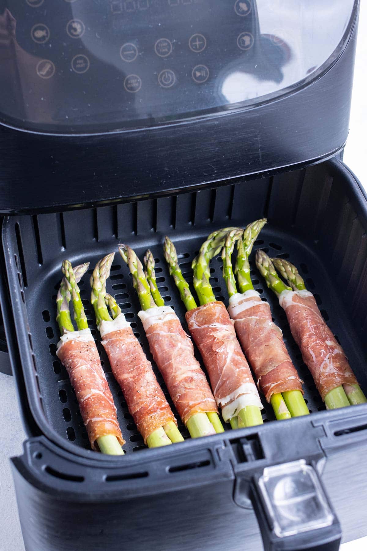 Prosciutto asparagus is cooked in an air fryer.
