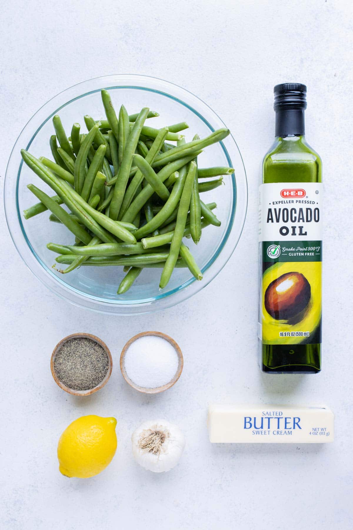 Green beans, oil, butter, garlic, salt, pepper, and lemon juice are the ingredients for this recipe.