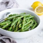 Cooked green beans are top with fresh lemon juice, salt, and pepper.