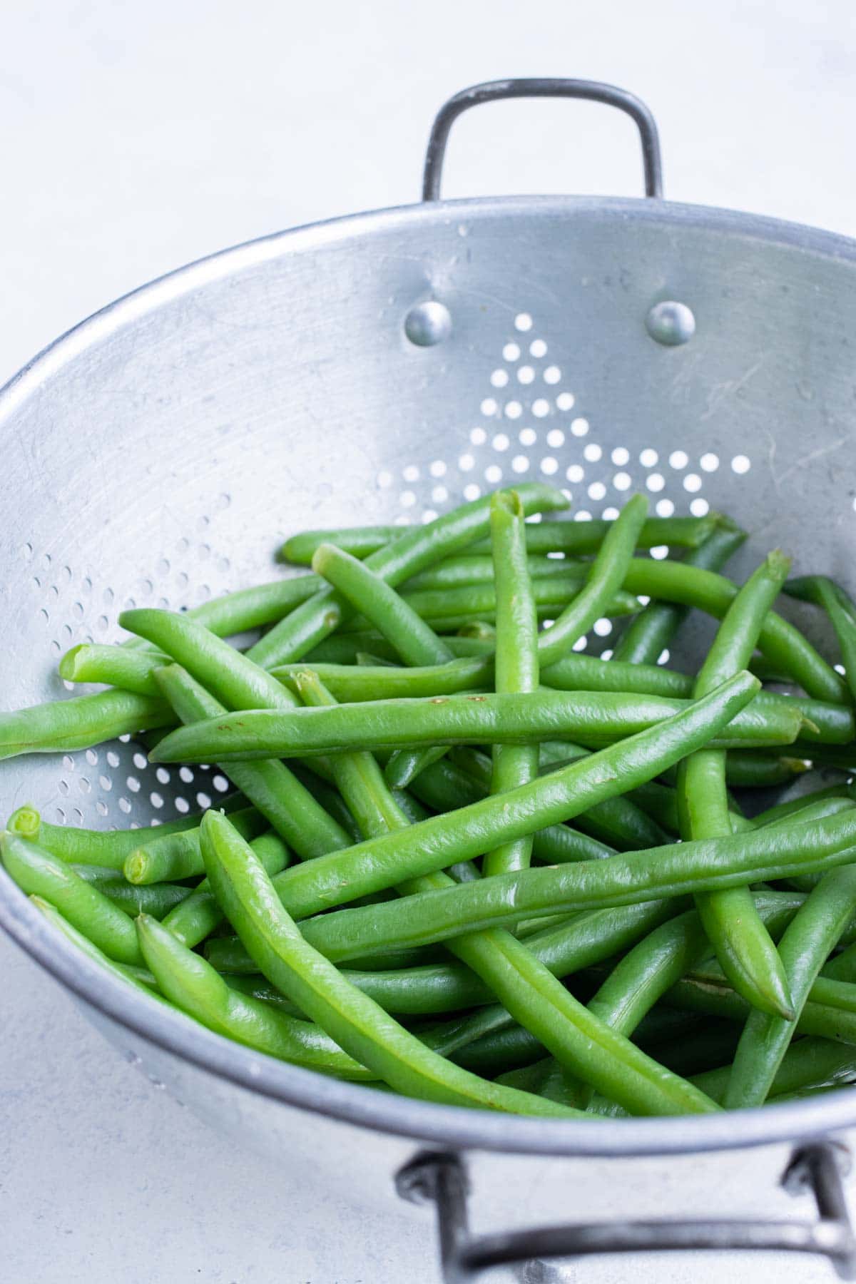 A strainer is used to remove the beans from the water.