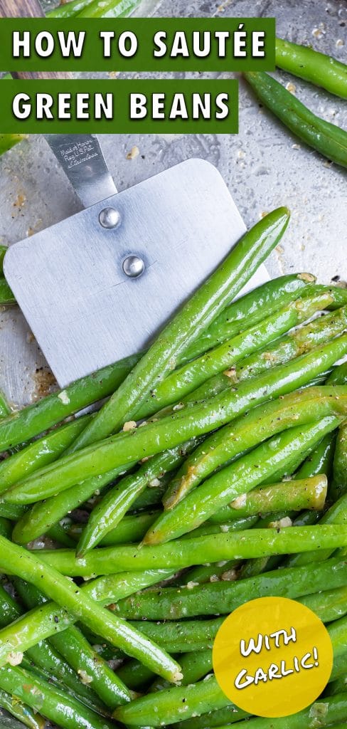 A metal spatula is used to remove the sautéed green beans from the pan.