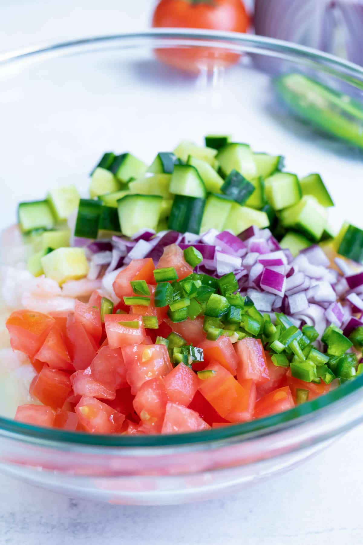 Diced vegetables are added to the shrimp ceviche.