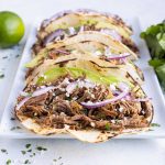 Barbacoa tacos are served on a plate for a healthy dinner.
