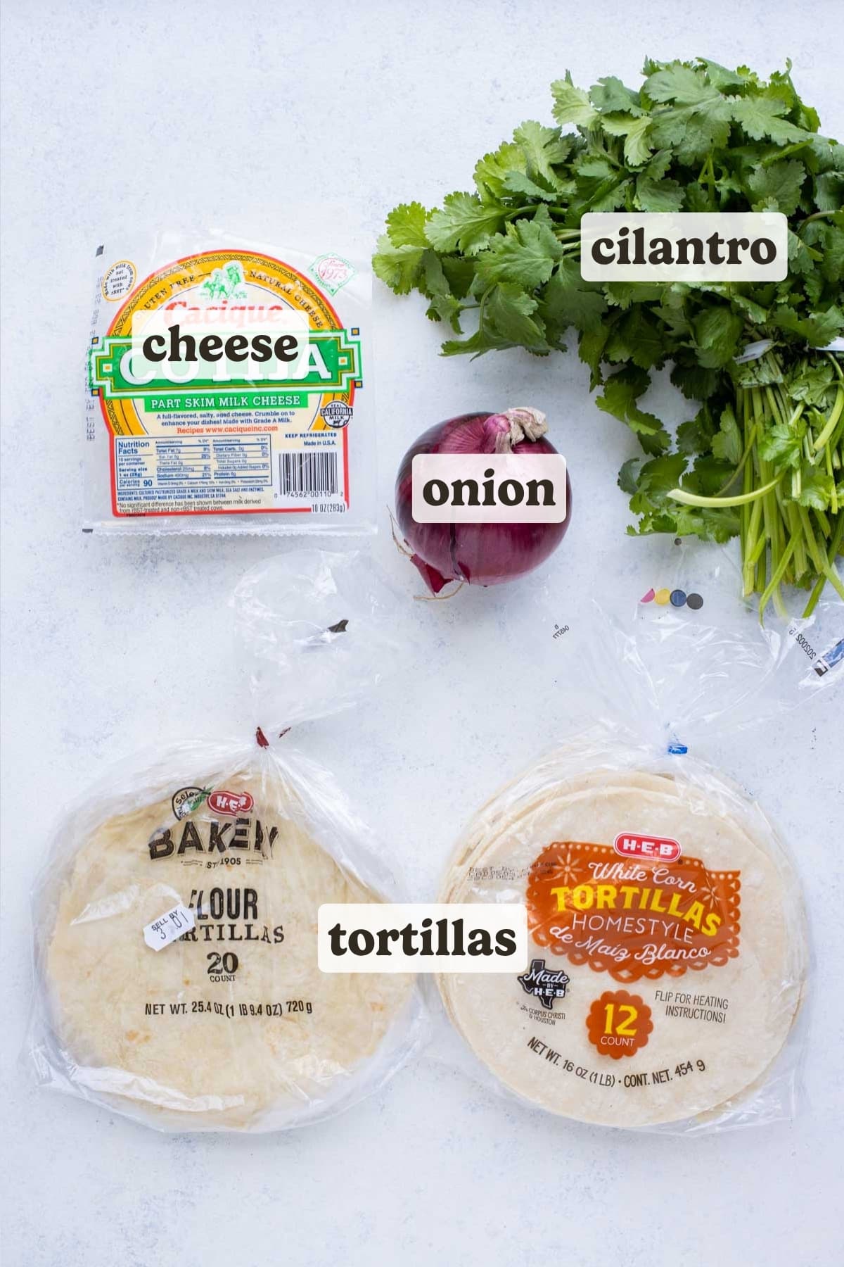 Tortillas, red onion, cilantro, and cotija cheese are the ingredients for these barbacoa tacos.