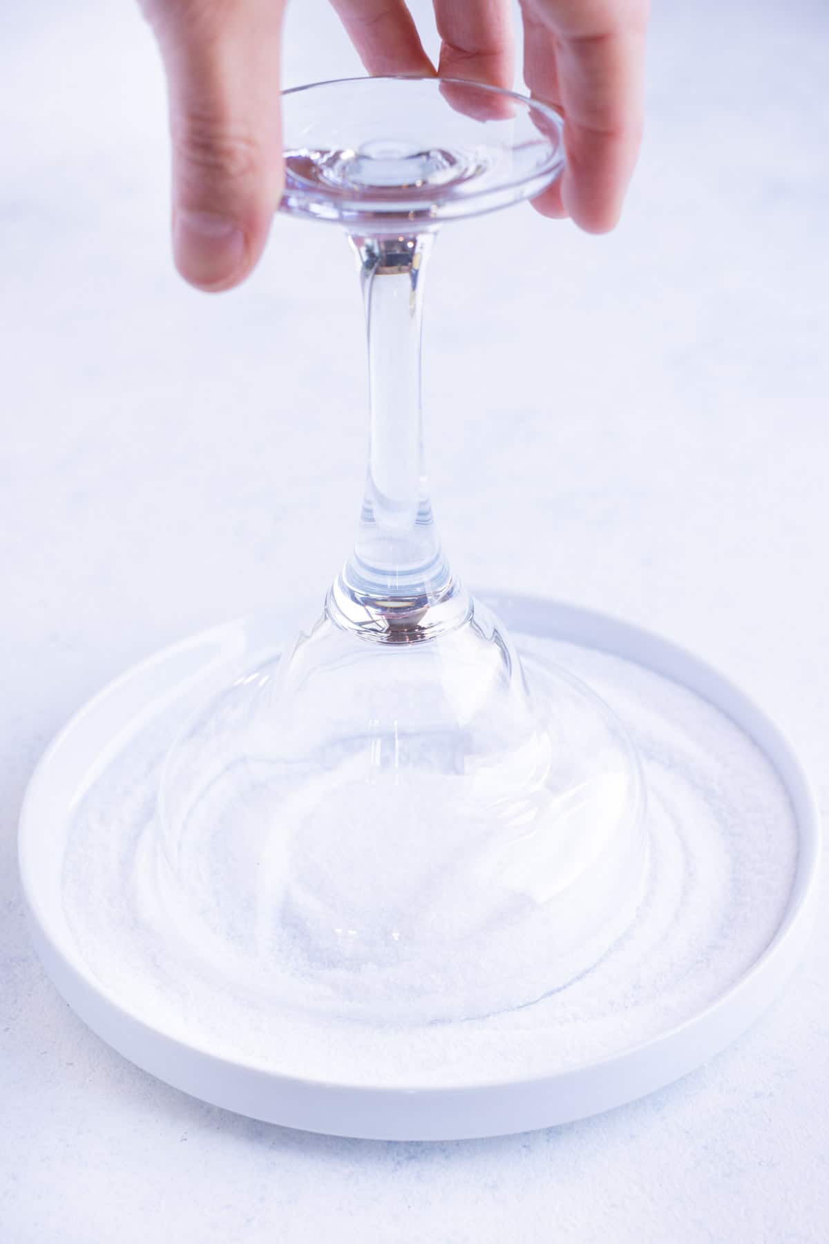 Glass is flipped upside down into a pile of salt.