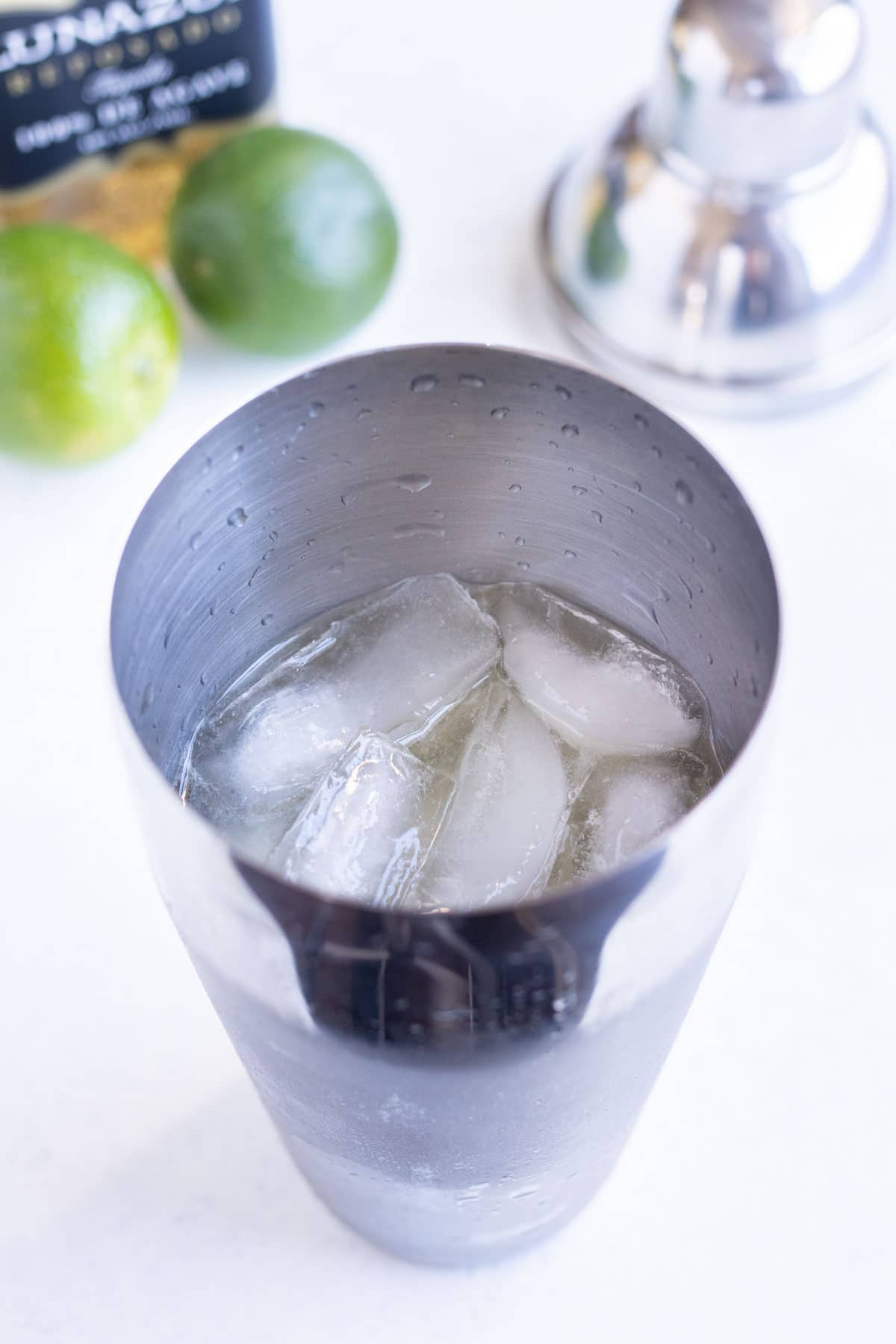 Ice and drink ingredients are add to the shaker.