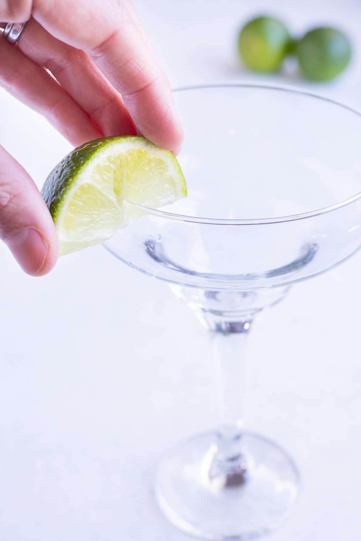 Lime wedges are used to salt the glass.