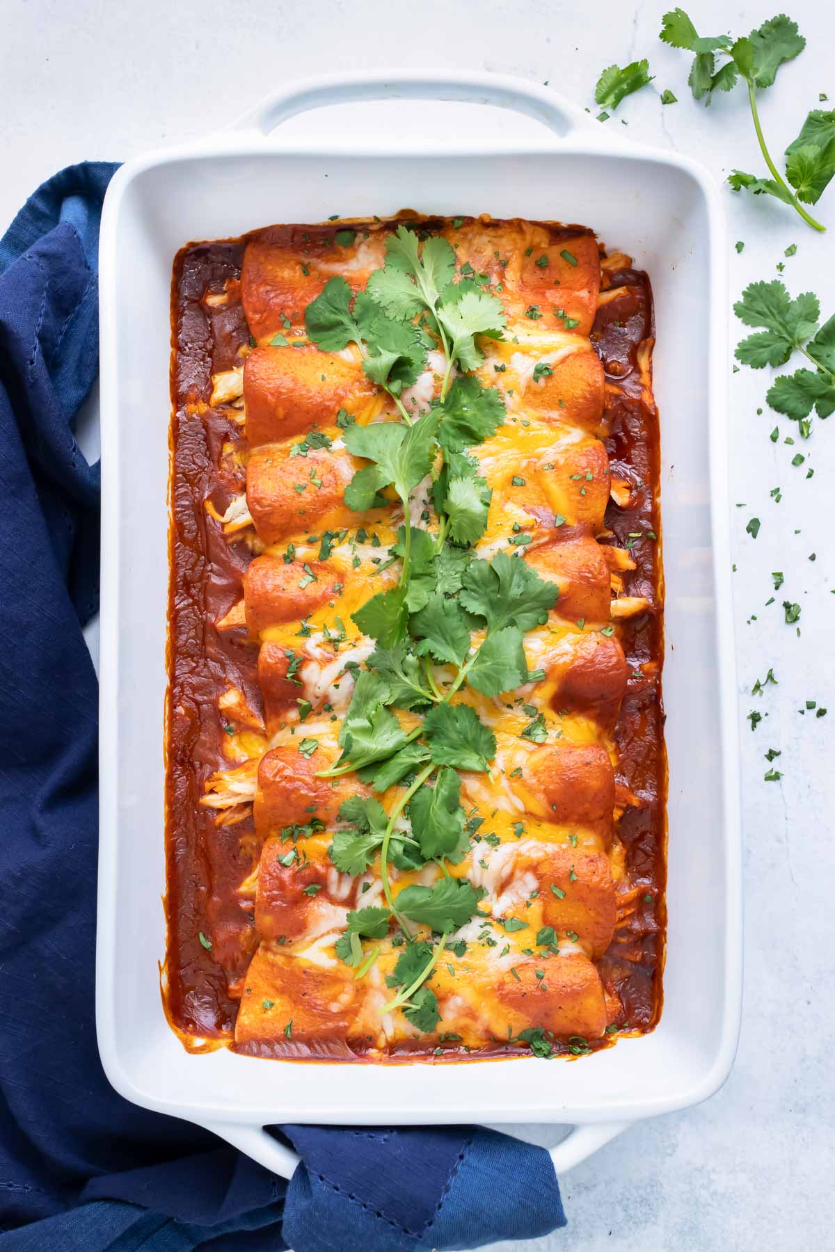 A large baking dish with an authentic and easy chicken Mexican casserole with cheese.