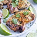 Quick and easy cilantro lime chicken is served on a white plate on the counter.