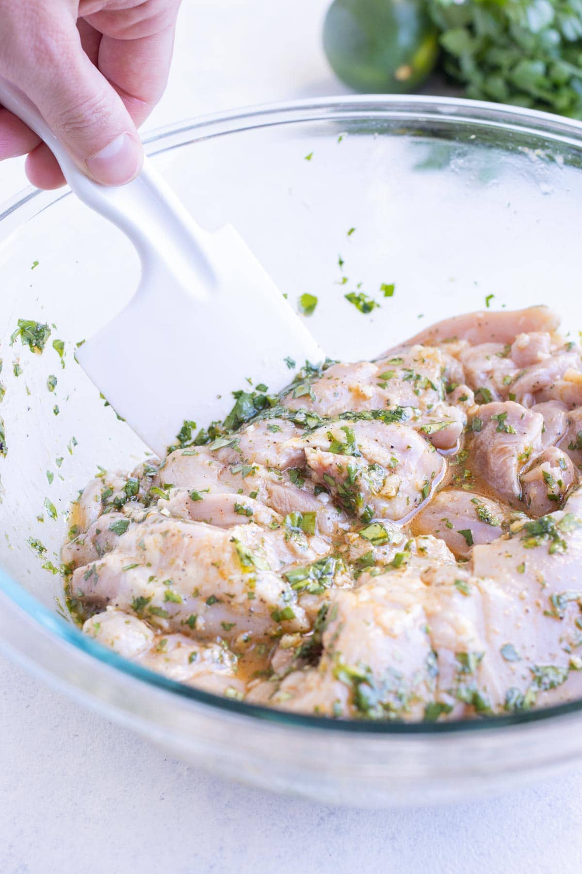 Chicken thighs are mixed into the marinade.