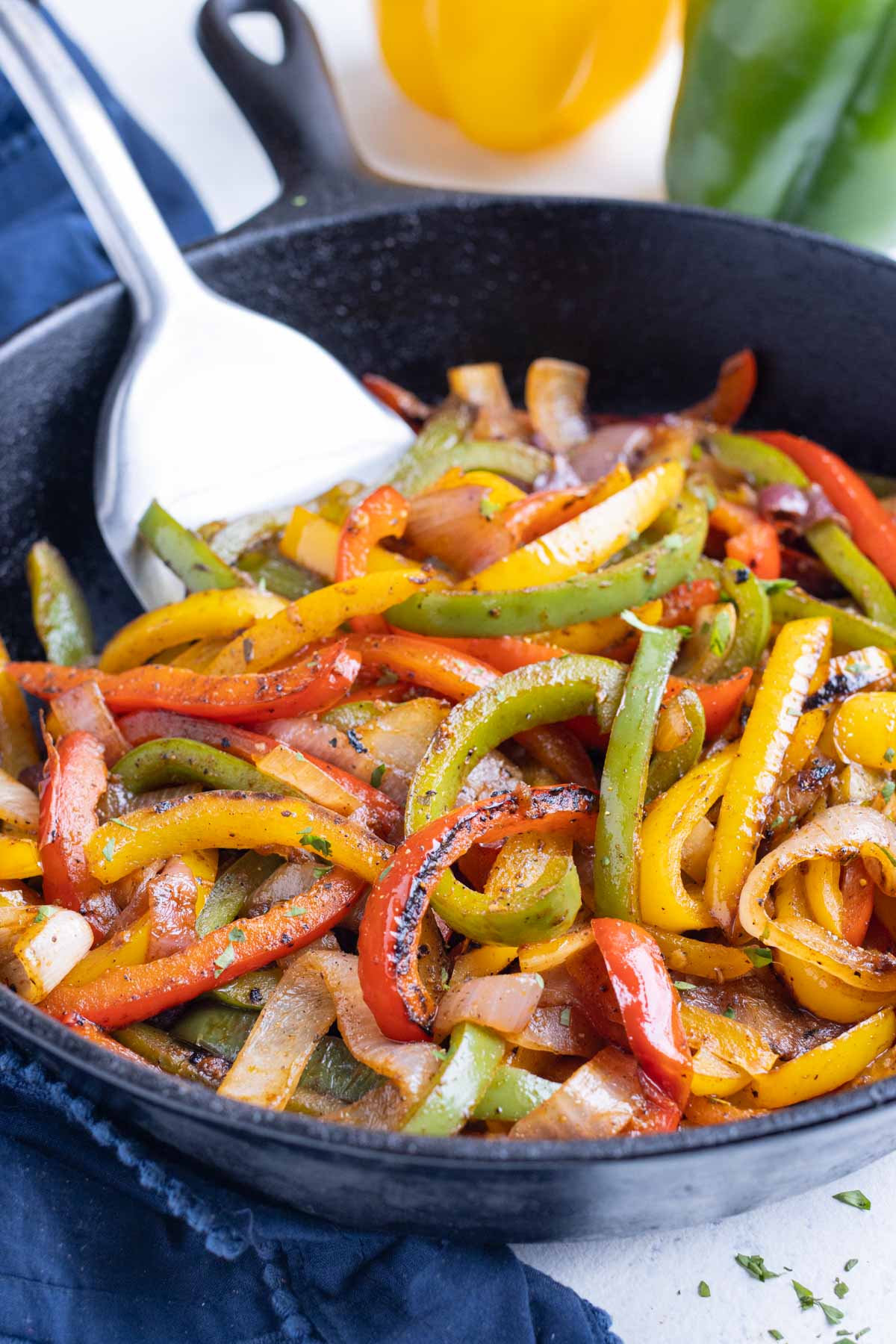 Chipotle fajita veggies are cooked until tender in a cast-iron skillet.