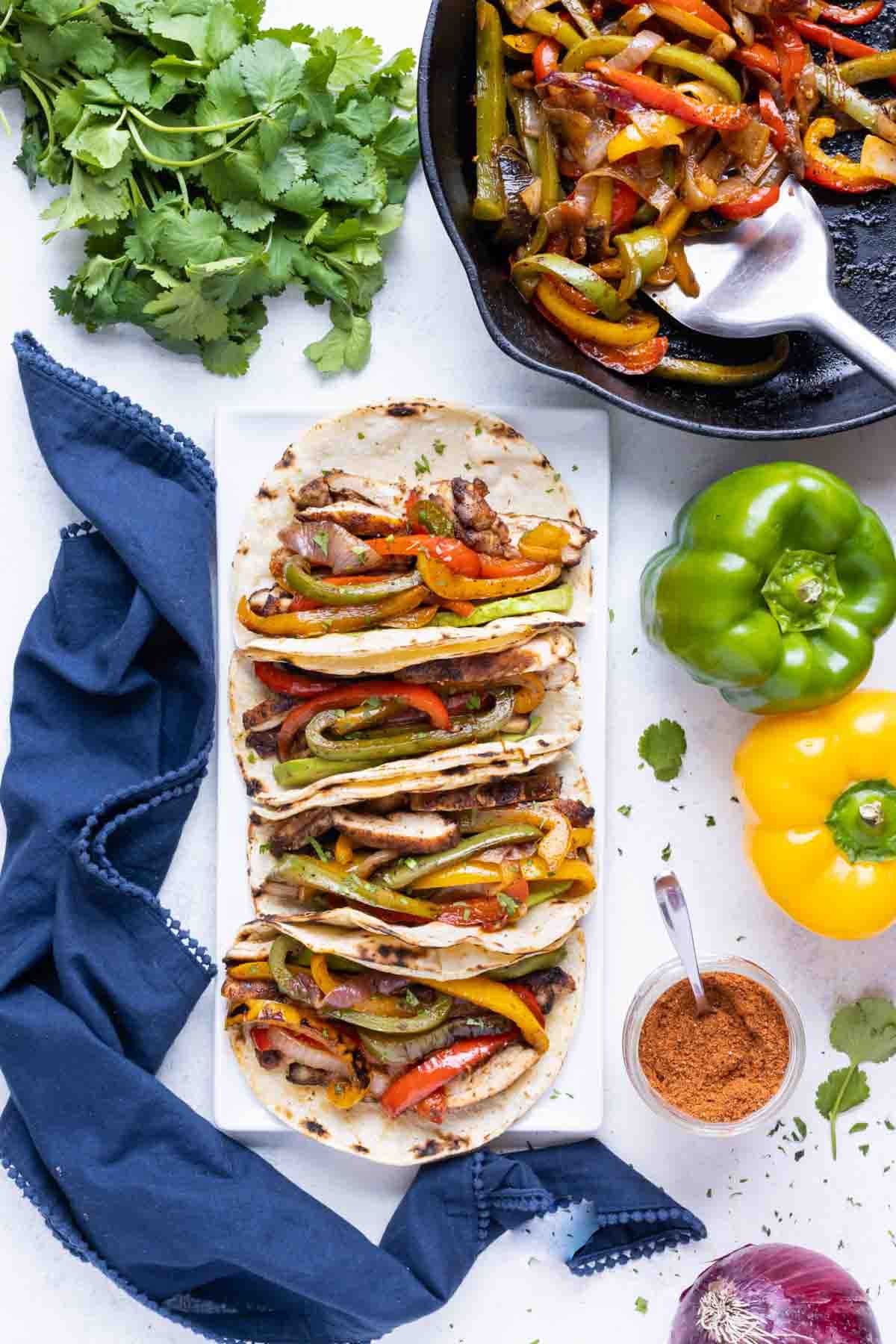 Steak fajitas are served in tacos with fajita veggies on the side.