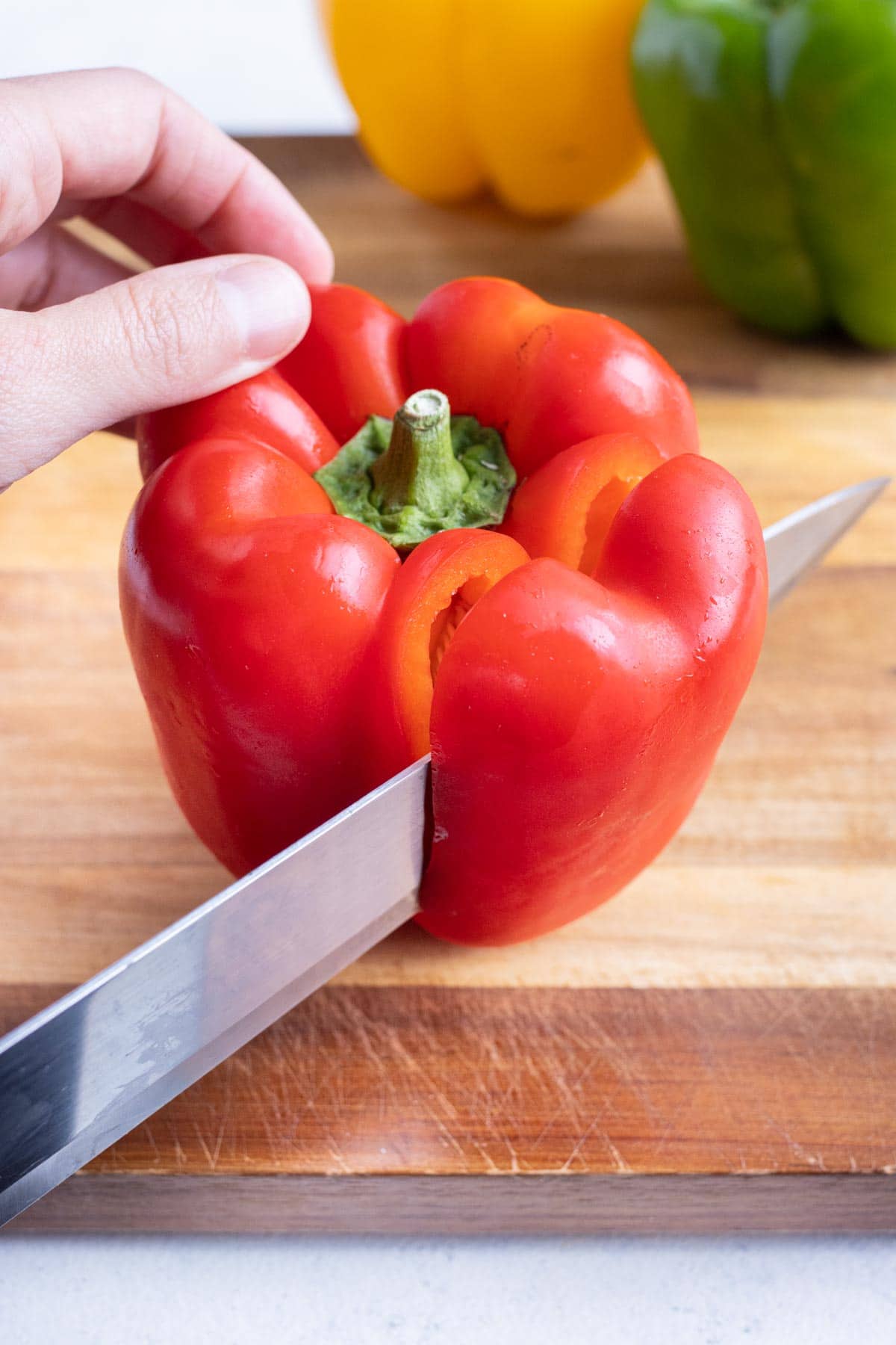 The bell peppers is cut down the sides surrounding the stem.