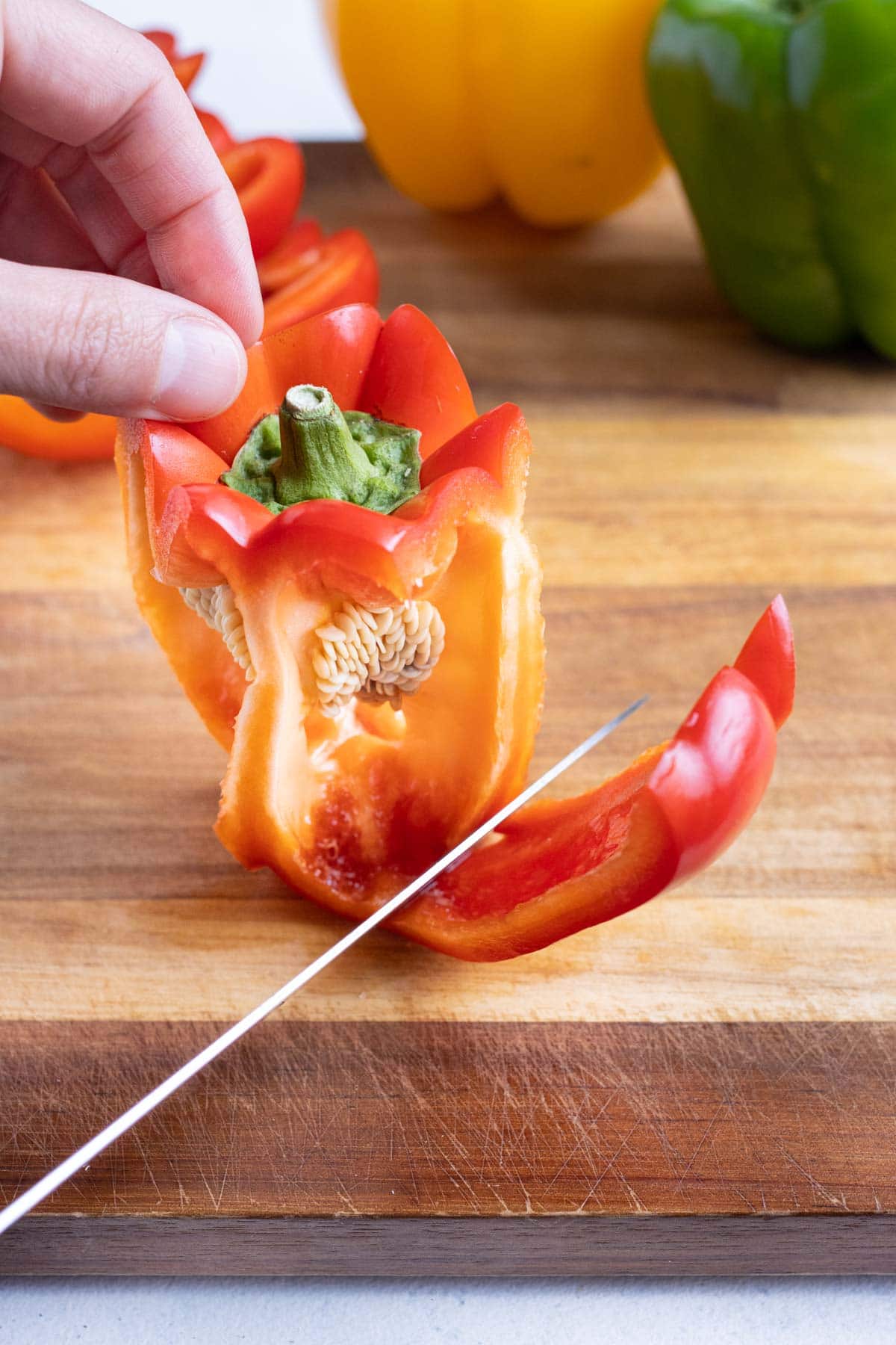 A knife is used to prepare the bell pepper.