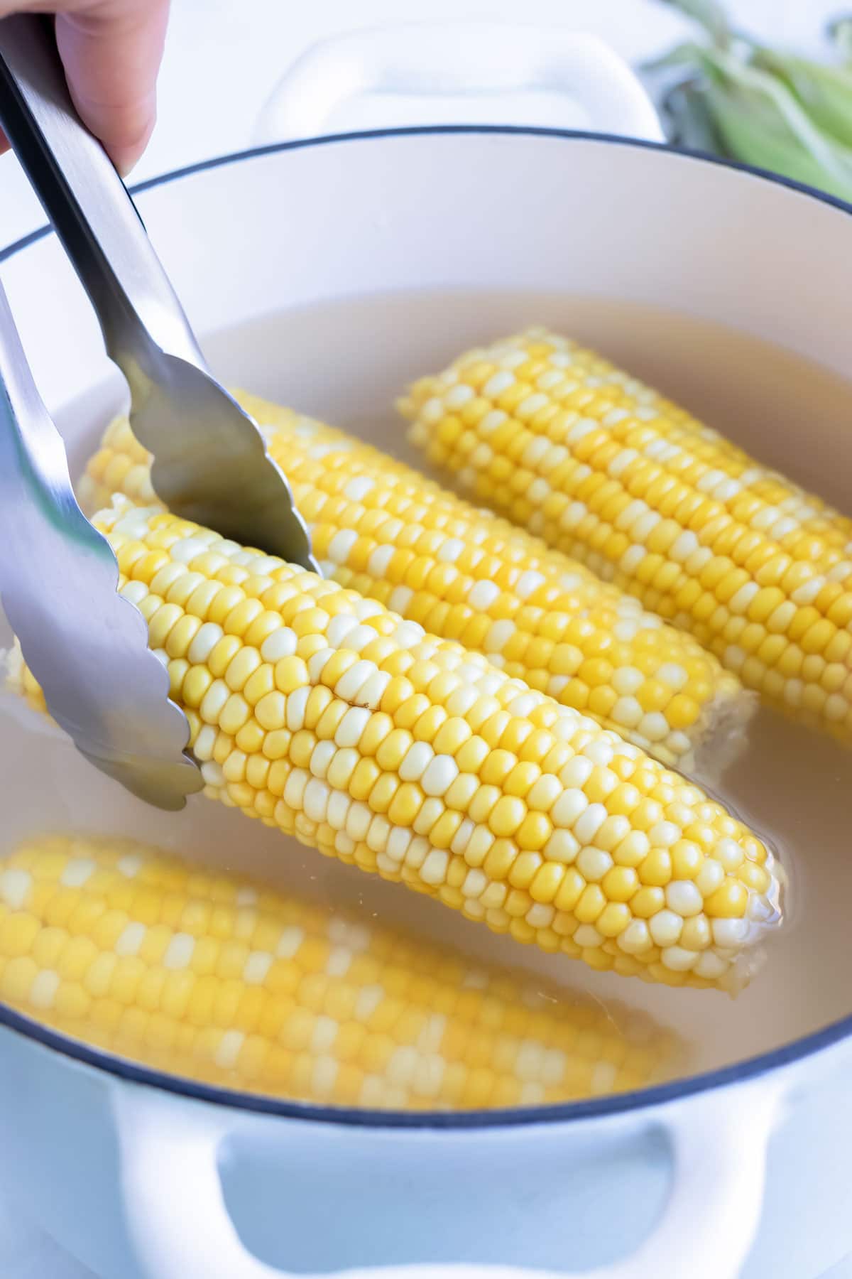 Corn is removed after being cooked in boiling water.
