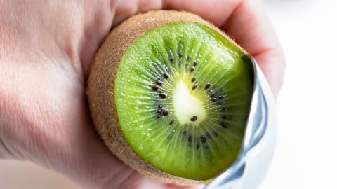 The kiwi half is removed and peeled with spoon method.