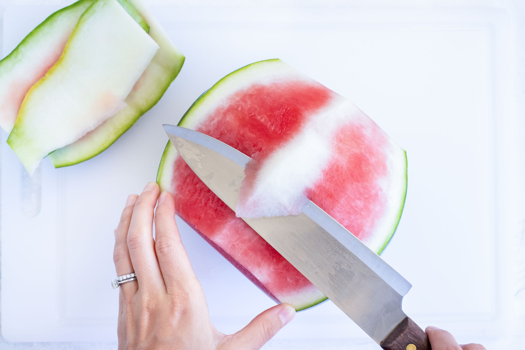 Removing the white rind of the watermelon after removing the outside