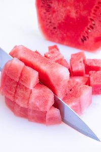 A cutting board with a rim around the edge to catch watermelon juice.