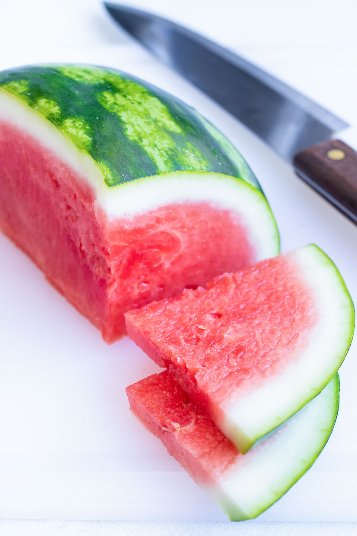 Slices next to quarter of a watermelon